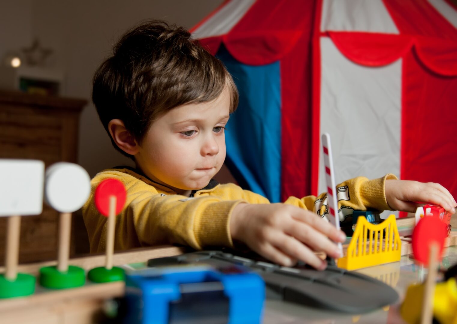Little toddler boy play in trains at home